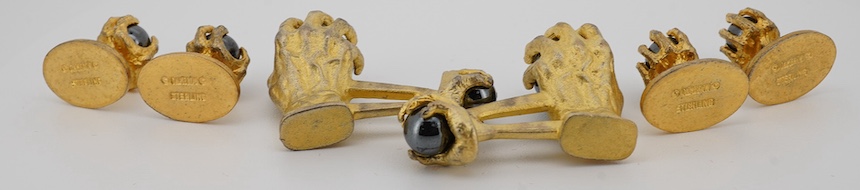 A modern gilt sterling and hematite set six piece dress stud set, modelled as a hand grasping a sphere, comprising a pair of cuff links 30mm and four studs. Condition - poor to fair